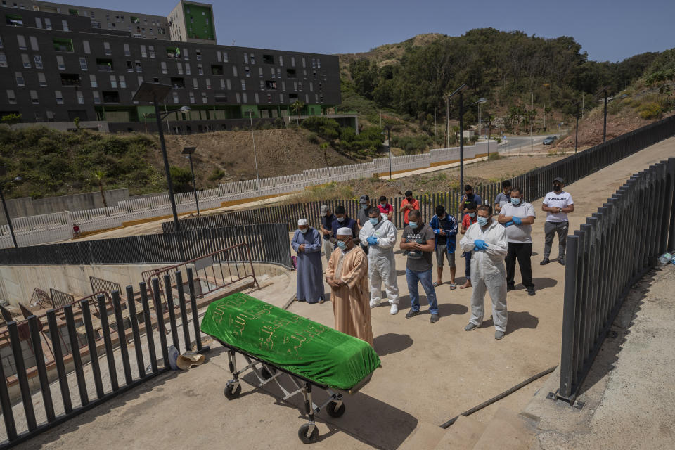 Ceuta residents and migrants perform a funeral prayer on a Moroccan teenager in the muslim cemetery at the Spanish enclave of Ceuta, Saturday, May 22, 2021. The young man died on Monday trying to swim across the border from Morocco to Spain's North Africa enclave with thousands of other migrants. (AP Photo/Bernat Armangue)