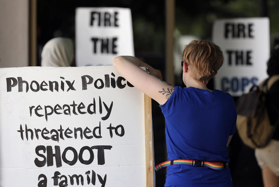 Protesters angered by a video of Phoenix officers who pointed guns and yelled obscenities at a black family they suspected of shoplifting gather outside City Council chambers, Wednesday, June 19, 2019, in Phoenix to demand reforms. Speakers called on the council to fire the officers involved in the videotaped incident and to create a board of civilians to oversee changes in department procedures. (AP Photo/Matt York)