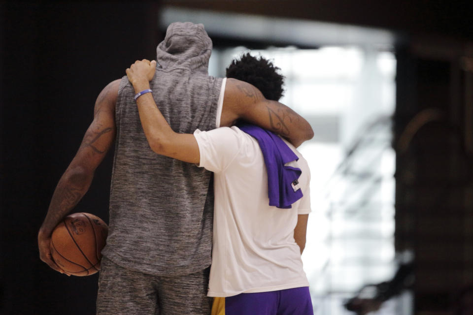 Los Angeles Lakers forward LeBron James, left, and guard Quinn Cook embrace at the end of NBA basketball practice in El Segundo, Calif., Thursday, Jan. 30, 2020. The Lakers held their second practice Thursday, while they continue to grieve for former player Kobe Bryant. (AP Photo/Damian Dovarganes)