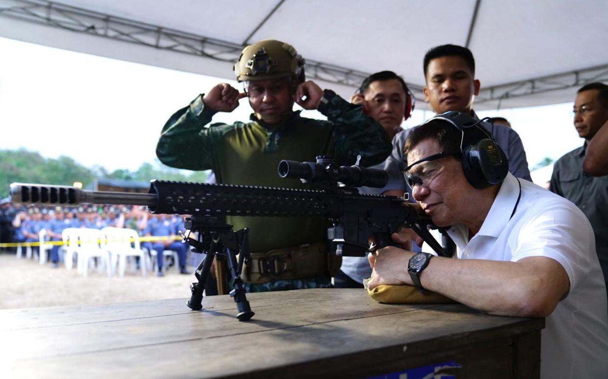 Rodrigo Duterte firing a few rounds with a sniper rifle during the opening ceremony of the National Special Weapons and Tactics. His relationship with the UN is becoming increasingly strained - AFP