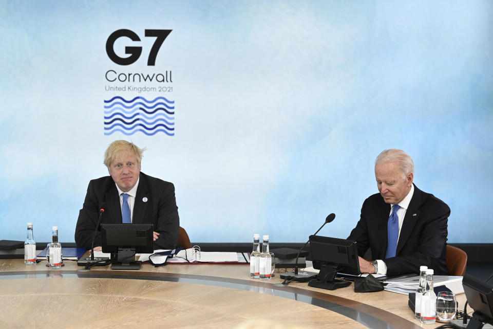 British Prime Minister Boris Johnson, left and US President Joe Biden sit around the table at the top of the G7 meeting, in Carbis Bay, Cornwall, England, Friday, June 11, 2021. (Leon Neal/Pool Photo via AP)