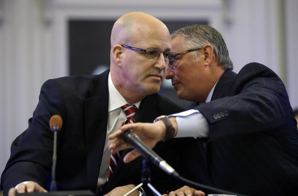 Michael Drewniak, left, chief spokesman for Gov. Chris Christie, listens to attorney Anthony Iacullo as Drew testifies Tuesday, May 13, 2014, before the state legislature's Select Committee on Investigation in Trenton, N.J. The committee is probing the politically motivated closure of access lanes to the George Washington Bridge in Fort Lee last September. (AP Photo/Mel Evans)