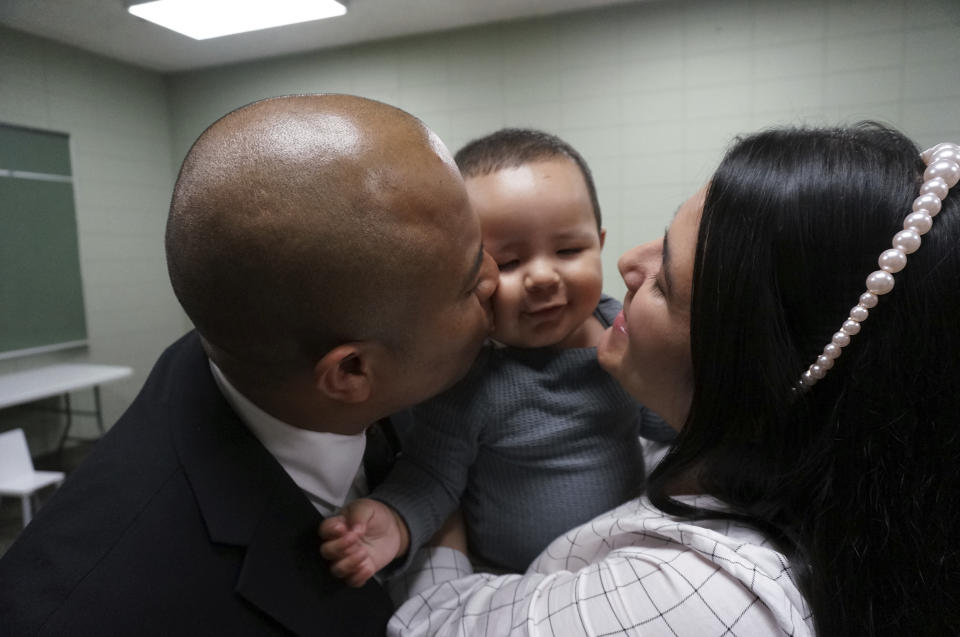 The Rev. Gustavo Castillo, left, and his wife, Yarleny, play with their 7-month-old son, Gustavo Jr., after a worship service at the Iglesia Pentecostal Unida Latinoamericana in Columbia Heights, Minn., on Sunday, Sept. 24, 2023. Born in Minnesota, Gustavo Jr. is a U.S. citizen, but his parents, who immigrated from Colombia on temporary religious workers visas, risk losing the ability to stay in the country after a sudden procedural change in how the U.S. government processes some green cards. (AP Photo/Giovanna Dell'Orto)