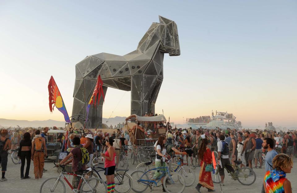 Hold for Story moving for Sunday AM's: In this file photo from Sept. 2, 2011, people gather around the Trojan Horse at it is pulled across the "playa" at the Burning Man festival in Gerlach, Nv. It's never been so hard to be a hippie. A quarter century after the free spirits moved their party from San Francisco's Baker Beach to a dried up ancient lake bed 110 miles north of Reno, the Burning Man counterculture festival is faced with turning large numbers of its longtime participants away. With its drum circles and decorated art cars, guerilla theatrics and colorful theme camps, the annual pilgrimage to the playa in the name of both everything and nothing has become just too darn popular for its own good. (AP Photo/Reno Gazette-Journal, Andy Barron) NO SALES; MAGS OUT; NEVADA APPEAL OUT; SOUTH RENO WEEKLY OUT