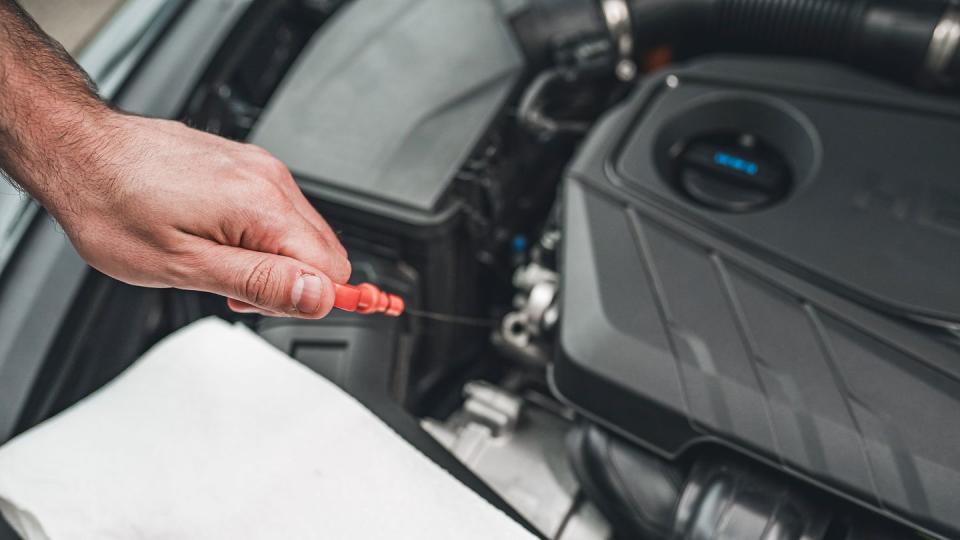 pulling oil dip stick from engine