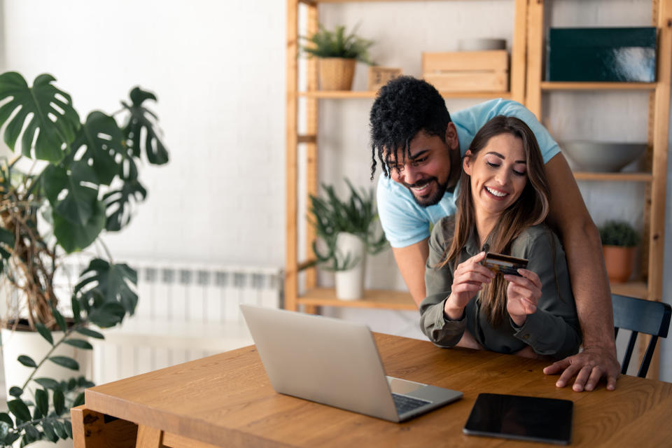 Young satisfied happy couple paying online with credit card, using laptop and online electronic banking. When it comes to budgeting, the right credit card can make a big difference