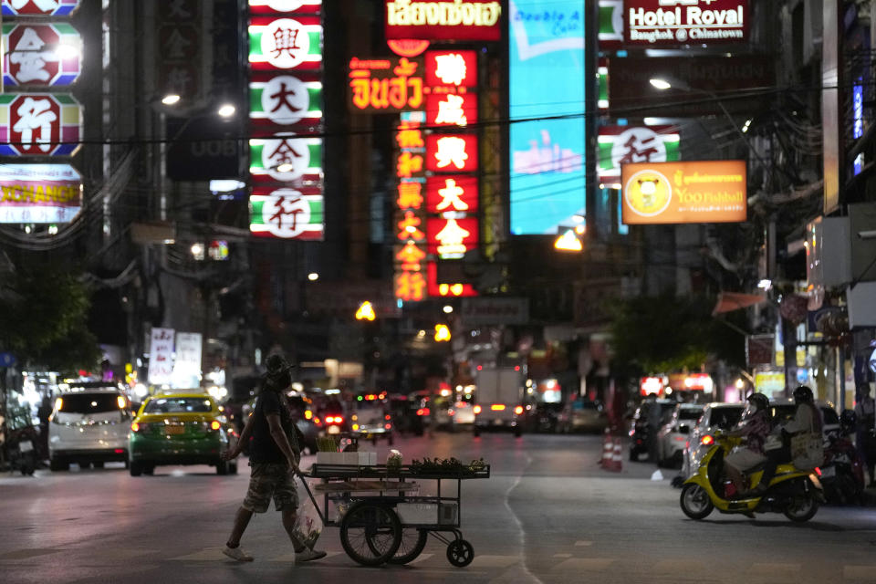 A vegetable vendor pushes his cart across a street in China town in Bangkok, Thailand, on Aug. 3, 2021. As Thailand battles a punishing COVID-19 surge with nearly 20,000 new cases every day, people who depend on tourism struggle in what was one of the most-visited cities in the world, with 20 million visitors in the year before the pandemic. (AP Photo/Sakchai Lalit)