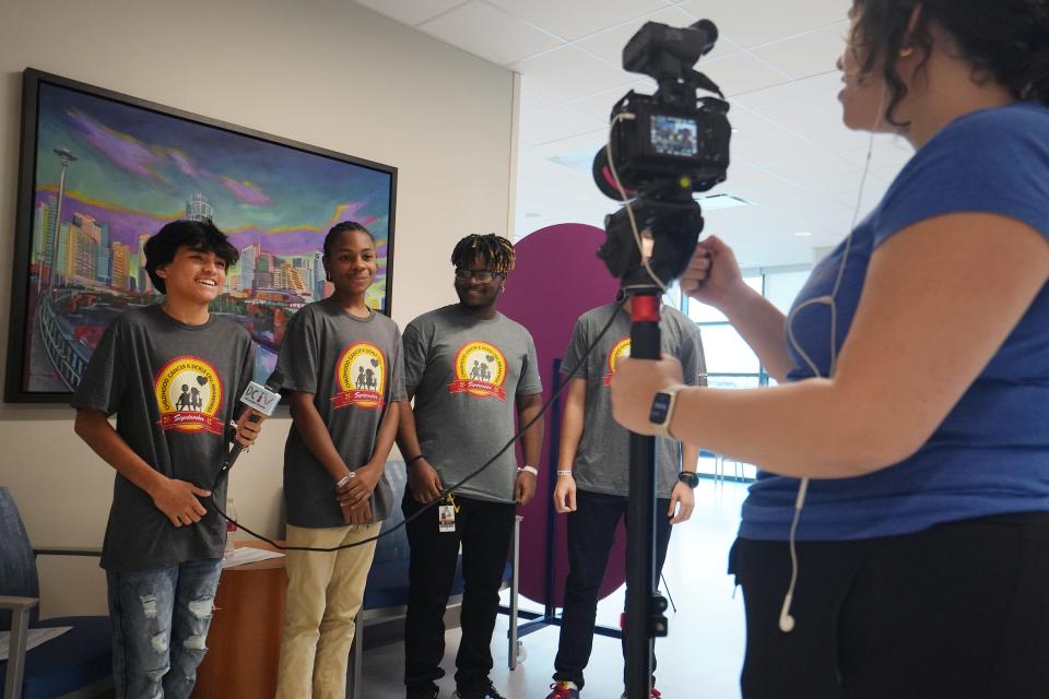 Alyssa Rueter, production coordinator for Dell Children's Medical Center's in-hospital TV channel, works on a video with the Sickle Cell Squad teen leadership council during their monthly meeting Sept. 6. From left, Izreal Turcios, Donalvon Ross, Chris Gibson and Christian Austin participated in a video for the DCTV channel.