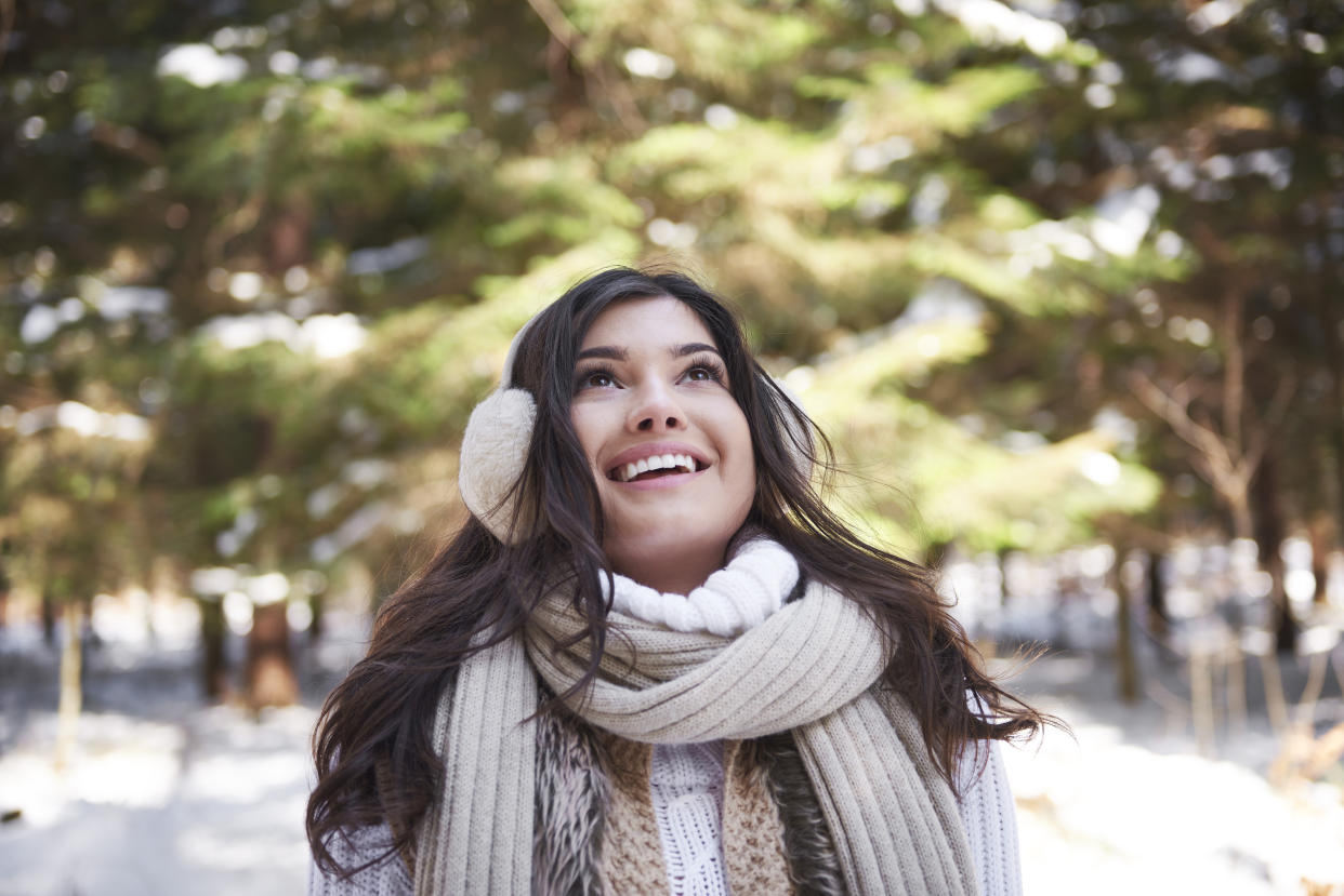 Portrait of happy young woman in winter forest