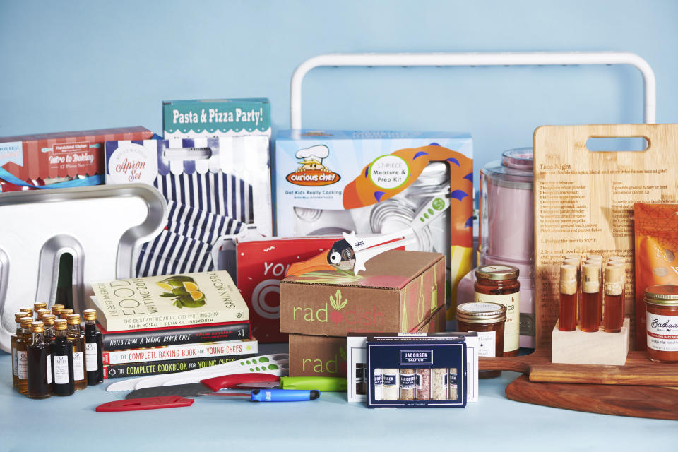 This November 2019 photo shows a plethora of great gift choices for young chefs on a table in New York. From cooking kits to ice cream makers to books to flights of honey, there are lots of way to fuel a budding cook's interest. (Cheyenne Cohen/Katie Workman via AP)