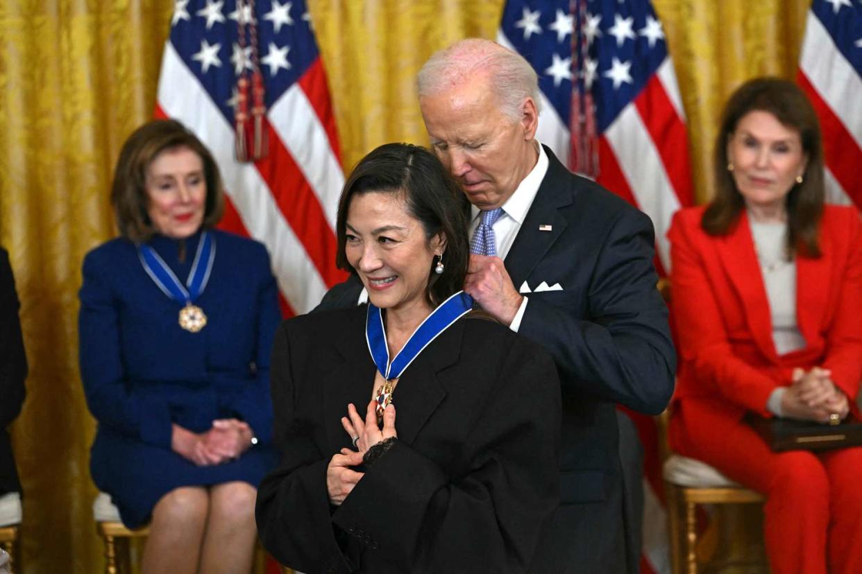 <p>ANDREW CABALLERO-REYNOLDS/AFP via Getty</p> Michelle Yeoh receives the Presidential Medal of Freedom from President Joe Biden