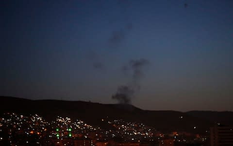 Smoke rises after airstrikes targeting different parts of the Syrian capital Damascus - Credit: AP