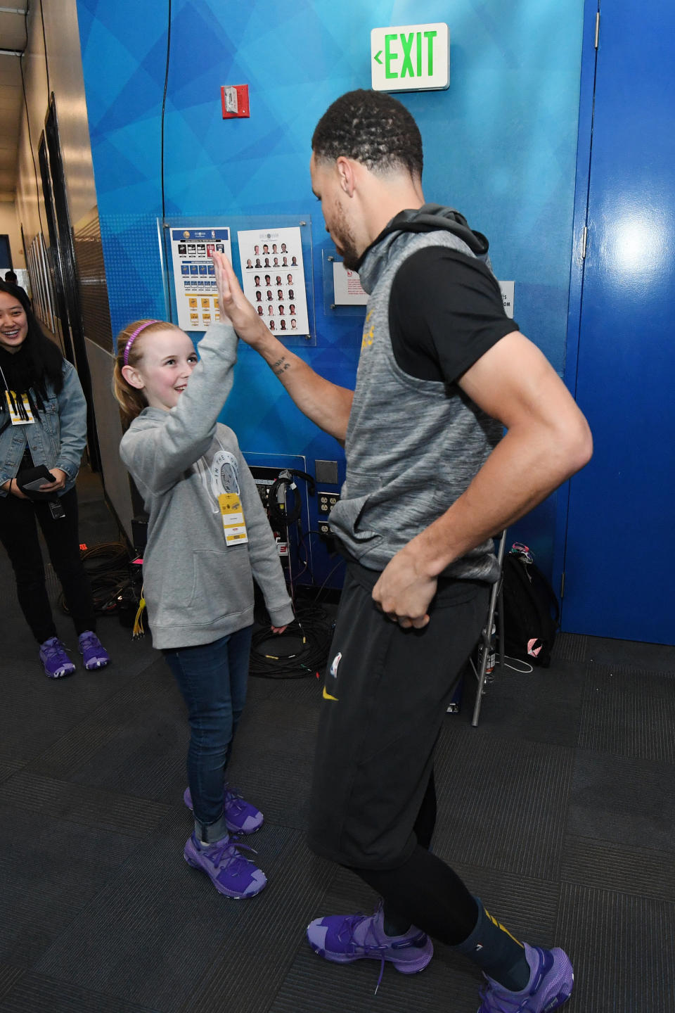 OAKLAND, CA - MARCH 8:  Riley Morrison high fives Stephen Curry #30 of the Golden State Warriors prior to the game against the Denver Nuggets on March 8, 2019 at ORACLE Arena in Oakland, California. NOTE TO USER: User expressly acknowledges and agrees that, by downloading and or using this photograph, user is consenting to the terms and conditions of Getty Images License Agreement. Mandatory Copyright Notice: Copyright 2019 NBAE (Photo by Noah Graham/NBAE via Getty Images)