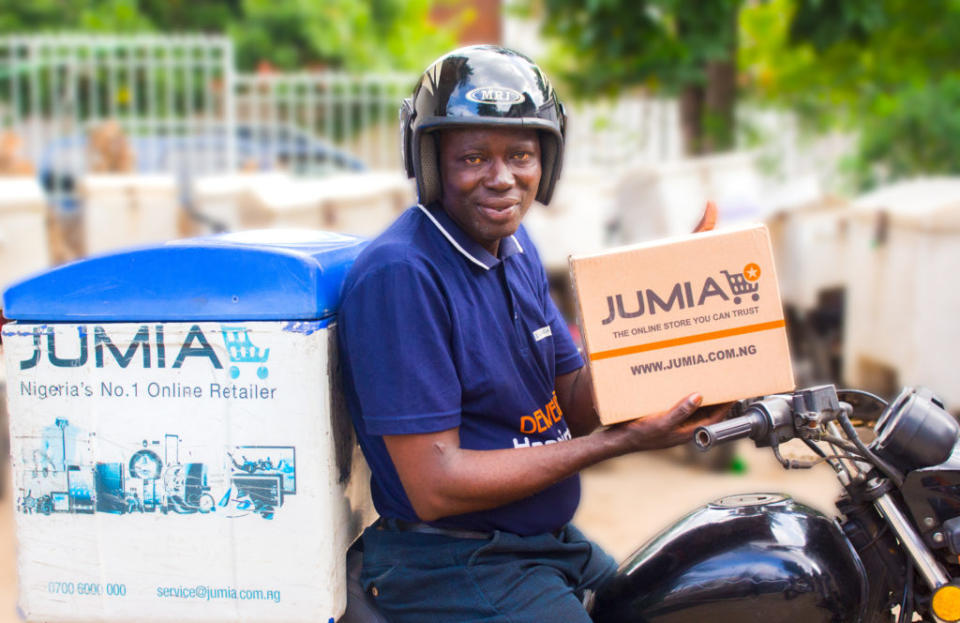 Jumia delivery driver on a motorcycle with a box with the Jumia logo.