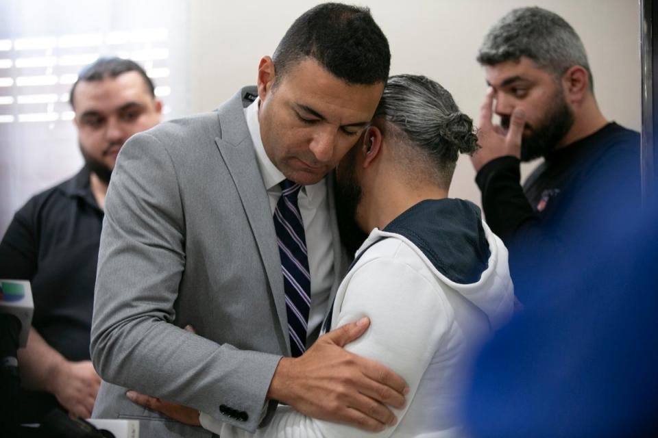 Ahmed Rehab, left, executive director of the Chicago chapter of the Council on American-Islamic Relations,  embraces Odey Al-Fayoume, father of Wadea Al-Fayoume, 6 (AP)
