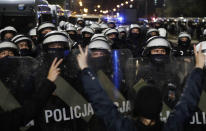 A police cordon guards the house of Poland's ruling conservative party leader Jaroslaw Kaczynski against a crowd protesting a decision by the Constitutional Court, in Warsaw, Poland, on Friday, Oct. 23, 2020. Poland’s top court ruled Thursday that a law allowing abortion of fetuses with congenital defects is unconstitutional, shutting a major loophole in the predominantly Catholic country's abortion laws that are among the strictest in Europe. Defying the pandemic-related ban on gatherings, the protesters chanted for the government to resign. (AP Photo/Czarek Sokolowski)