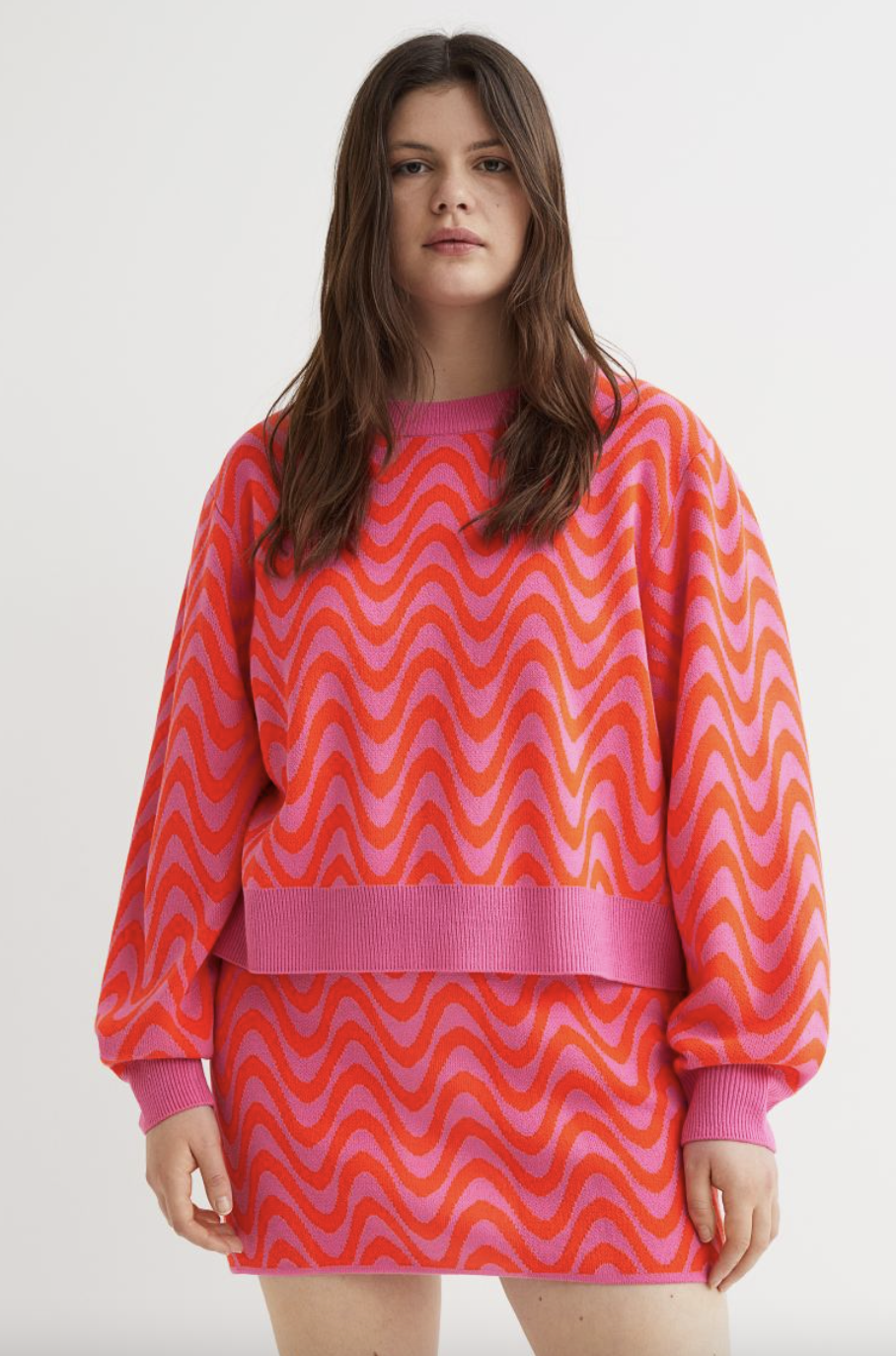 plus size model in pink and orange striped H&M+ Sweater (Photo via H&M)