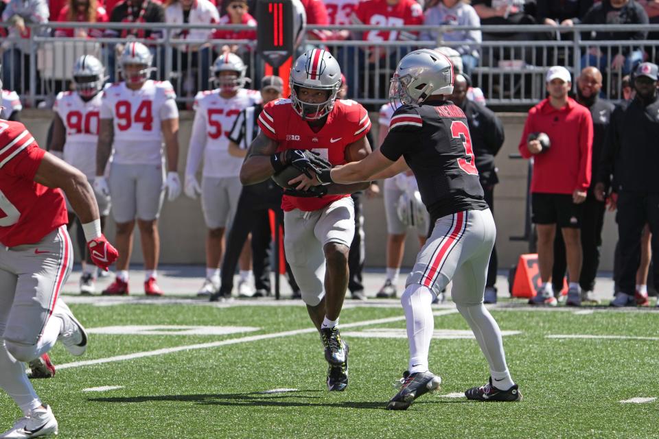 Apr 13, 2024; Columbus, OH, USA; Ohio State Buckeyes quarterback Lincoln Kienholz (3) hands the ball off to Ohio State Buckeyes wide receiver Jeremiah Smith (4) during the Ohio State football spring game at Ohio Stadium.