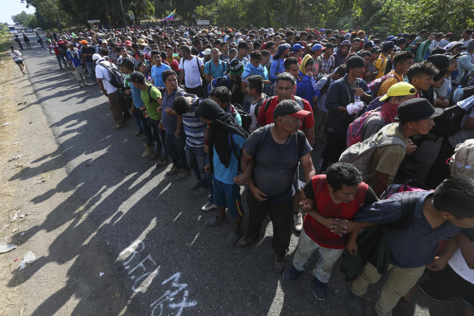 Migrantes forman una cadena sujetándose por los brazos en una carretera hacia Tapachula, México, el 23 de enero de 2020, donde se encotnraron con un dispositivo de la Guardia Nacional que les bloqueó el paso. (AP Foto/Marco Ugarte)