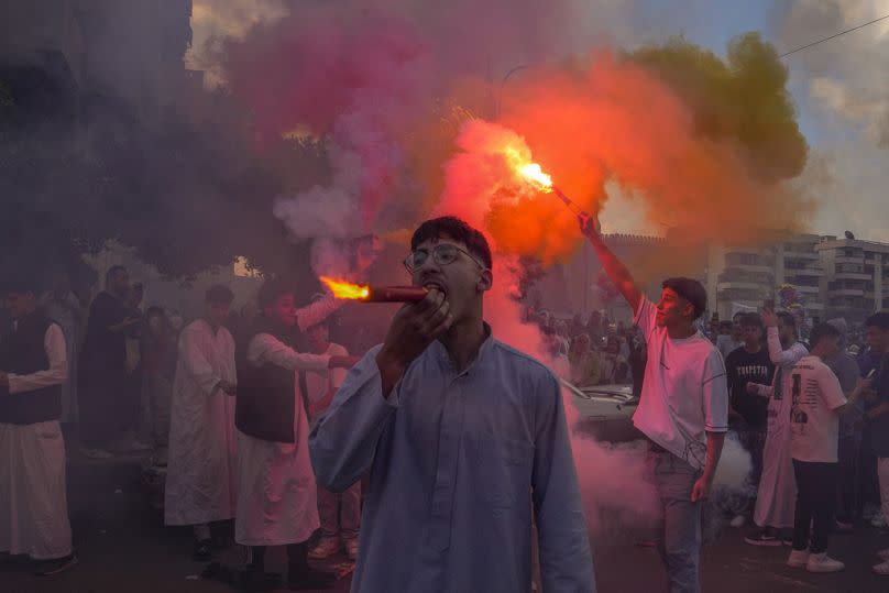 Muslims light flares as they celebrate Eid al-Fitr outside al-Seddik mosque in Cairo, Egypt, Wednesday, April 10, 2024.