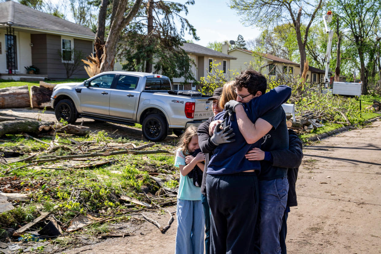 Neighbors embrace Penny Thomsen outside of her home in Pleasant Hill (Zach Boyden-Holmes / The Des Moines Register via USA Today Network)