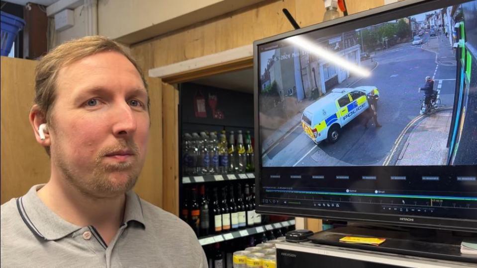 Justin Fenn standing next to his CCTV monitor