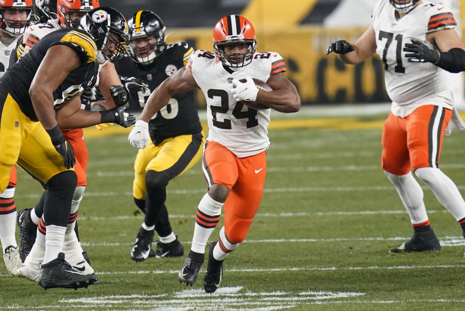 Cleveland Browns running back Nick Chubb (24) runs through a hole during the first half of an NFL wild-card playoff football game against the Pittsburgh Steelers, Sunday, Jan. 10, 2021, in Pittsburgh. (AP Photo/Keith Srakocic)