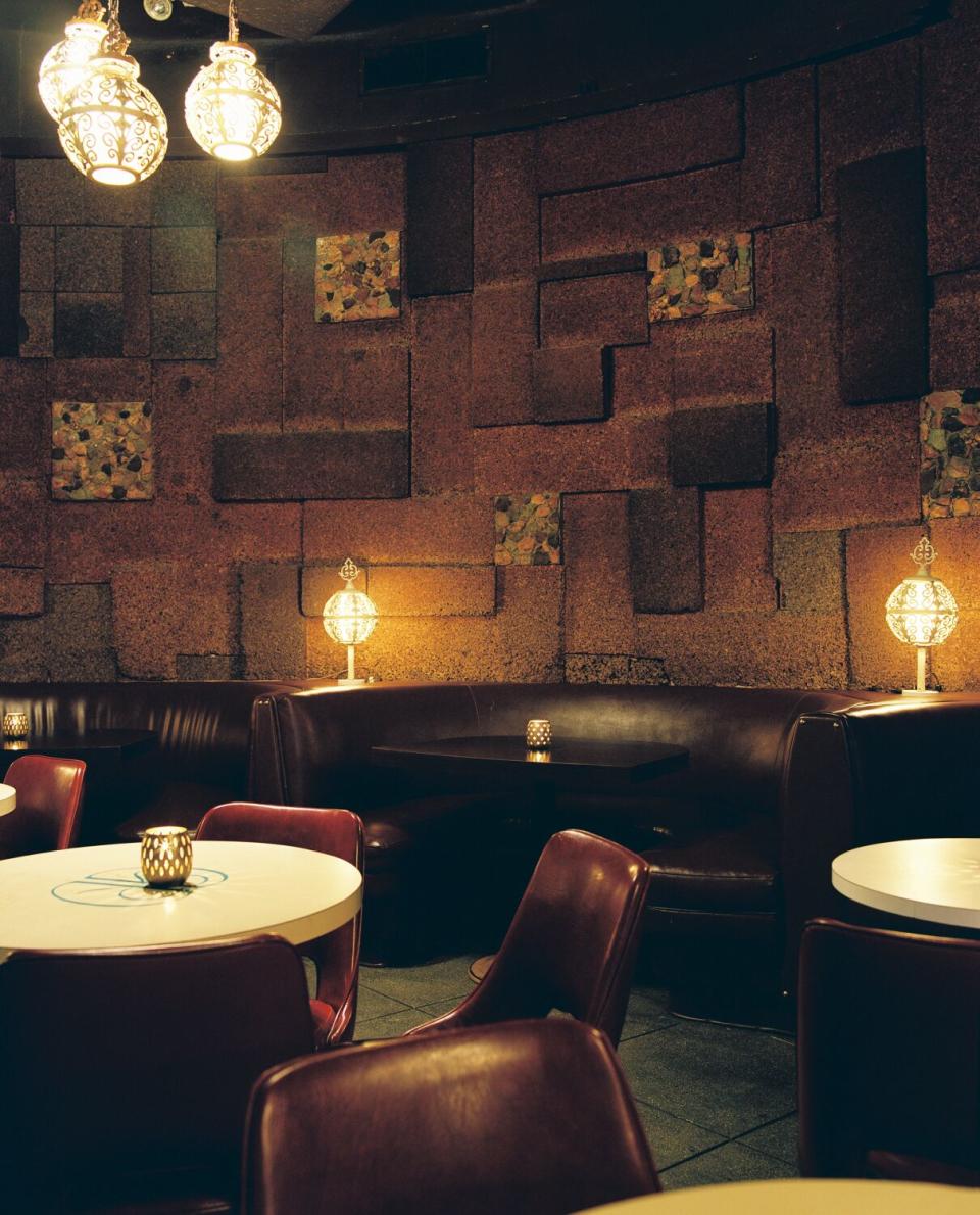 A photo of brown and burgundy booths and white tables.