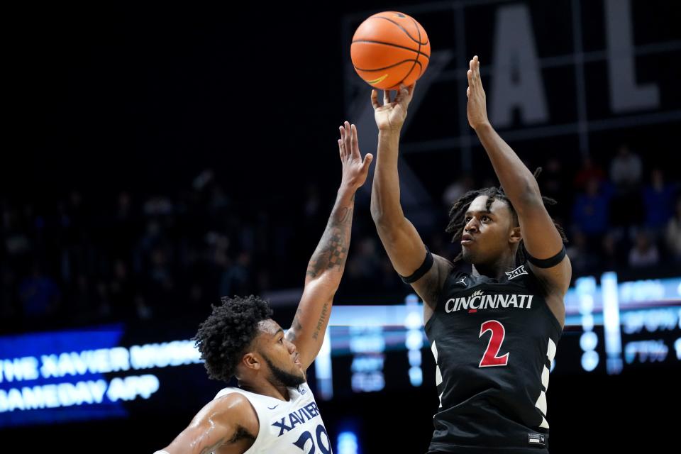 Cincinnati Bearcats guard Jizzle James (2) rises for a shot as Xavier Musketeers guard Dayvion McKnight (20) defends in the first half of the 91st Crosstown Shootout basketball game between the Cincinnati Bearcats and the Xavier Musketeers, Saturday, Dec. 9, 2023, at Cintas Center in Cincinnati.