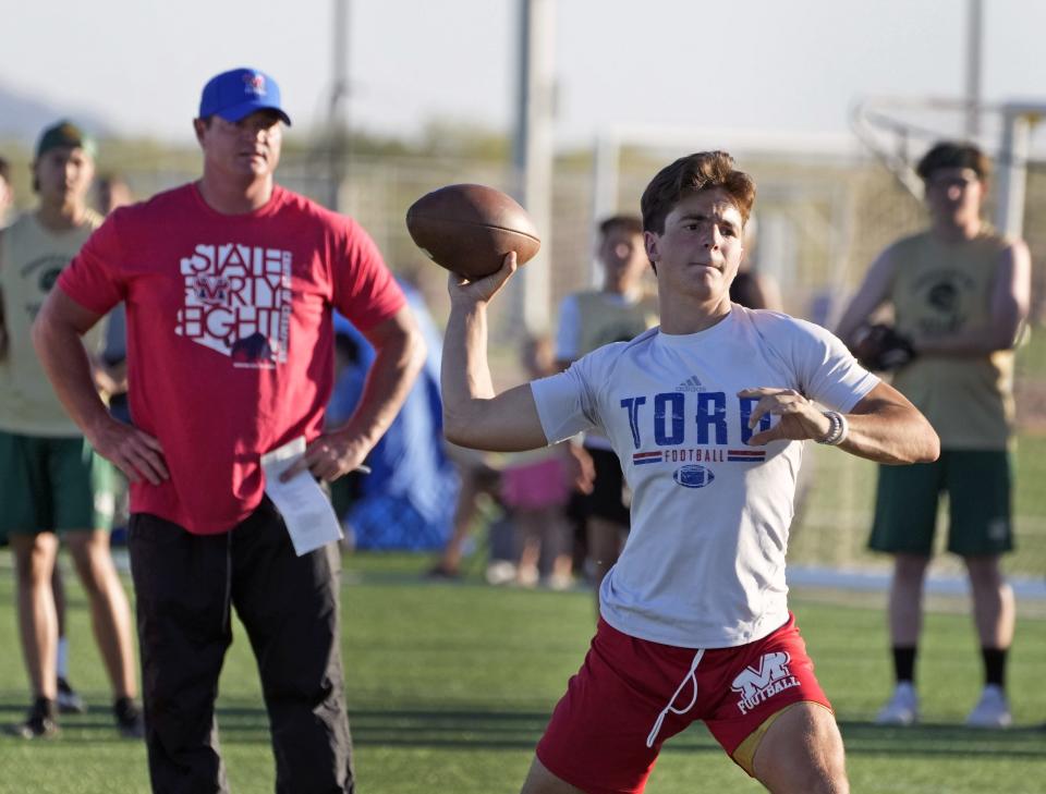 Jun 15, 2022; Mesa, AZ, USA;  Mountain View head coach Joe Germaine, watches his son, Jack, pass the ball, during a 7-on-7 passing league football tournament at Bell Bank Park in Mesa.