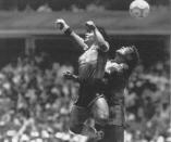 FILE - In this June 22, 1986 file photo, Argentina's Diego Maradona, left, beats England's goalkeeper Peter Shilton to a high ball and scores his first of two goals at the World Cup quarterfinal soccer match in Mexico City. On this day: This was the day of the "Hand of God," when Maradona used his left fist to knock a ball past England's Shilton. (El Grafico via AP, File)