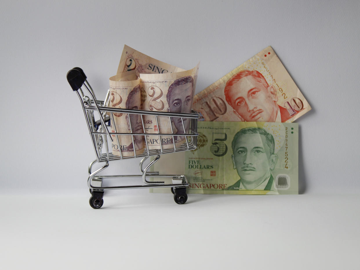 shopping cart and Singaporean banknotes of different denomination