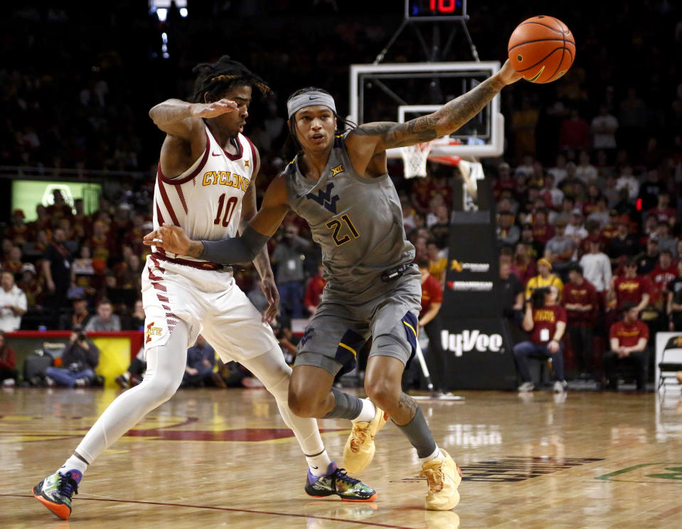 West Virginia guard RaeQuan Battle (21) looks to save the ball after Iowa State guard Keshon Gilbert (10) knocked it away in the first half during an NCAA college basketball game, Saturday, Feb. 24, 2024, in Ames, Iowa. (AP Photo/Bryon Houlgrave)