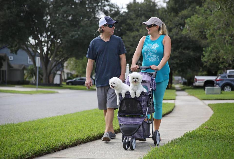 James and Lindsey Johnson walk Mako and Kona through their Winter Park neighborhood. The dogs bring the couple much joy and have helped assuage the grief over the loss of their son.