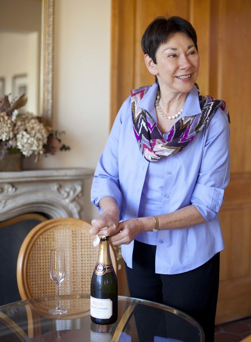 In this photo taken Wednesday, Nov. 14, 2012, CEO and winemaker Eileen Crane opens a bottle of Brut Cuvee sparkling wine at Domaine Carneros in Napa, Calif. Something new is bubbling up in the world of cocktails, using sparkling wine as a mixer. (AP Photo/Eric Risberg)