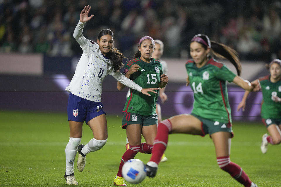 United States forward Sophia Smith (11) and Mexico defender Cristina Ferral (15) watch as Mexico defender Greta Espinoza (14) clears the ball during a CONCACAF Gold Cup women's soccer tournament match, Monday, Feb. 26, 2024, in Carson, Calif. (AP Photo/Ryan Sun)