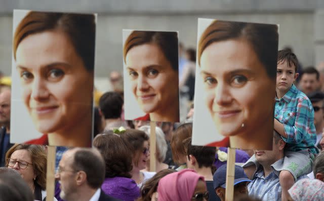 People hold banners of Jo Cox during a special service .