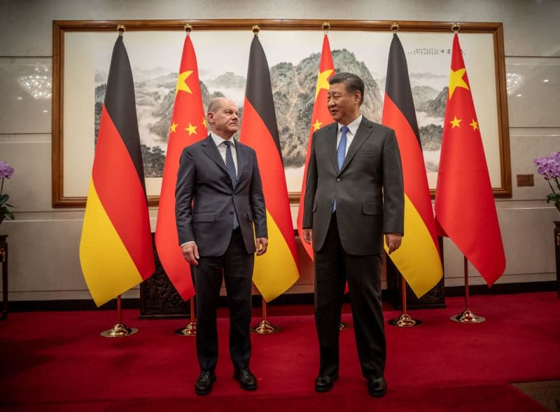 Chinese President Xi Jinping (R) welcomes German Chancellor Olaf Scholz at the State Guest House. Michael Kappeler/dpa