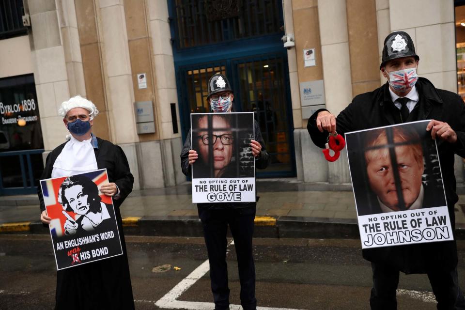 Anti Brexit protesters hold signs as the Chancellor of the Duchy of Lancaster Michael Gove leaves the third meeting of the EU-UK Joint Committee outside the UK representation in Brussels, Monday (AP)