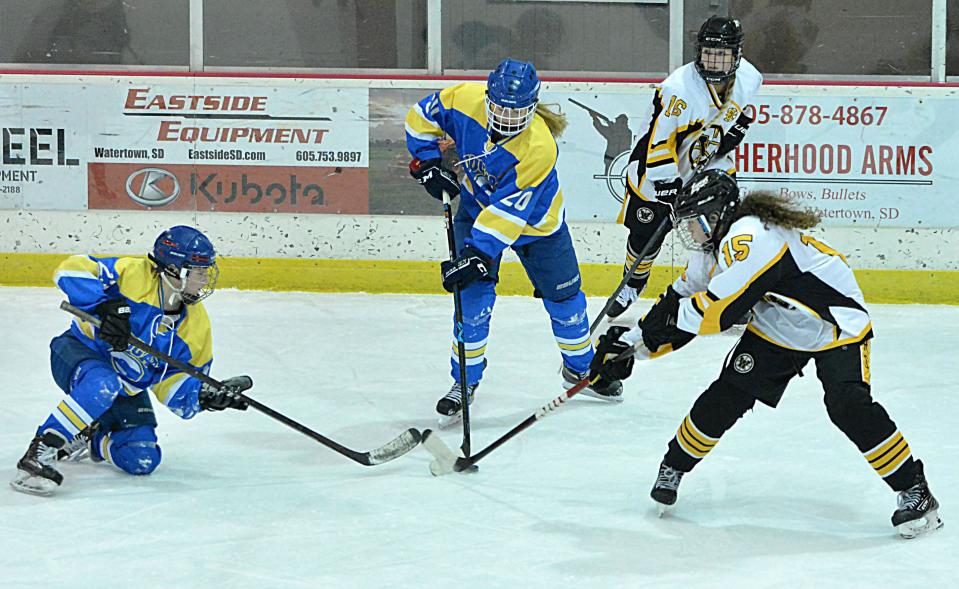 Rachel Siefken (left) and Morgan Jones (20) of the Aberdeen Cougars fight to gain control of the puck against Lily Murray of the Watertown Lakers during their South Dakota Amateur Hockey Association varsity girls' game on Friday, Jan. 26, 2024. Aberdeen won 6-0. Looking on is Watertown's Kayla Randall.