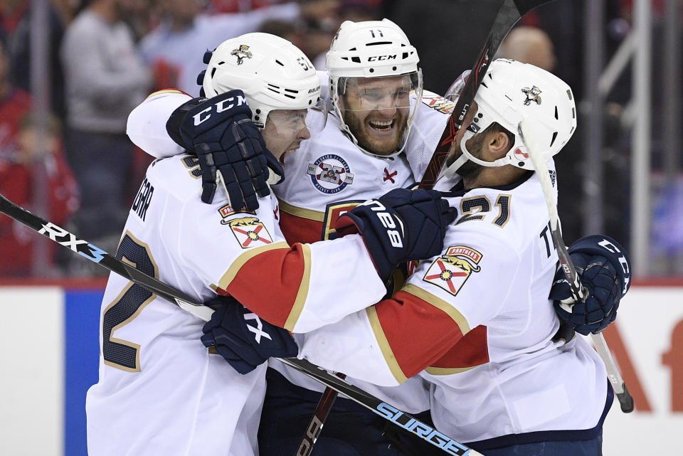 Florida Panthers left wing Jonathan Huberdeau (11) celebrates with defenseman MacKenzie Weegar, left, and center Vincent Trocheck, right, after an NHL hockey game against the Washington Capitals, Friday, Oct. 19, 2018, in Washington. Huberdeau scored the deciding shootout goal. The Panthers won 6-5 in a shootout. (AP Photo/Nick Wass)