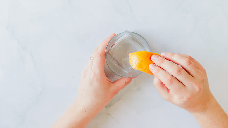 Running a grapefruit wedge along a cocktail glass rim