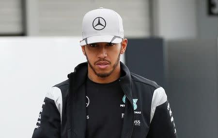 Mercedes' Lewis Hamilton of Britain walks in the paddock area before the third practice session. REUTERS/Toru Hanai