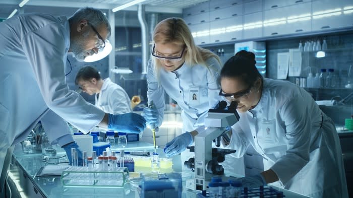 Four people working in a laboratory.