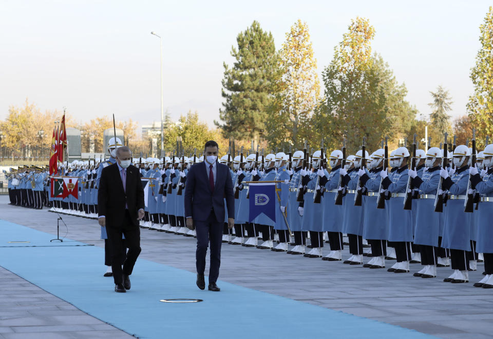 Turkey's President Recep Tayyip Erdogan, left, and Spanish Prime Minister Pedro Sanchez review a military honour guard during a welcoming ceremony at the presidential palace, in Ankara, Turkey, Wednesday, Nov. 17, 2021. (AP Photo/Burhan Ozbilici)