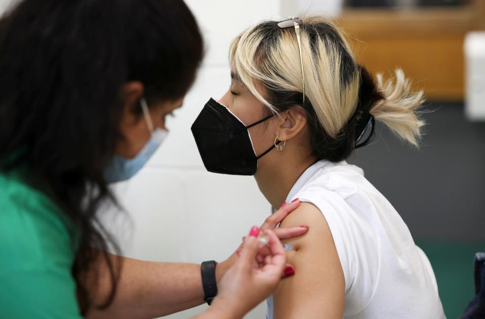 Someone receiving their dose of the Pfizer/BioNTech vaccine at the Belmont Health Centre in Harrow (REUTERS)