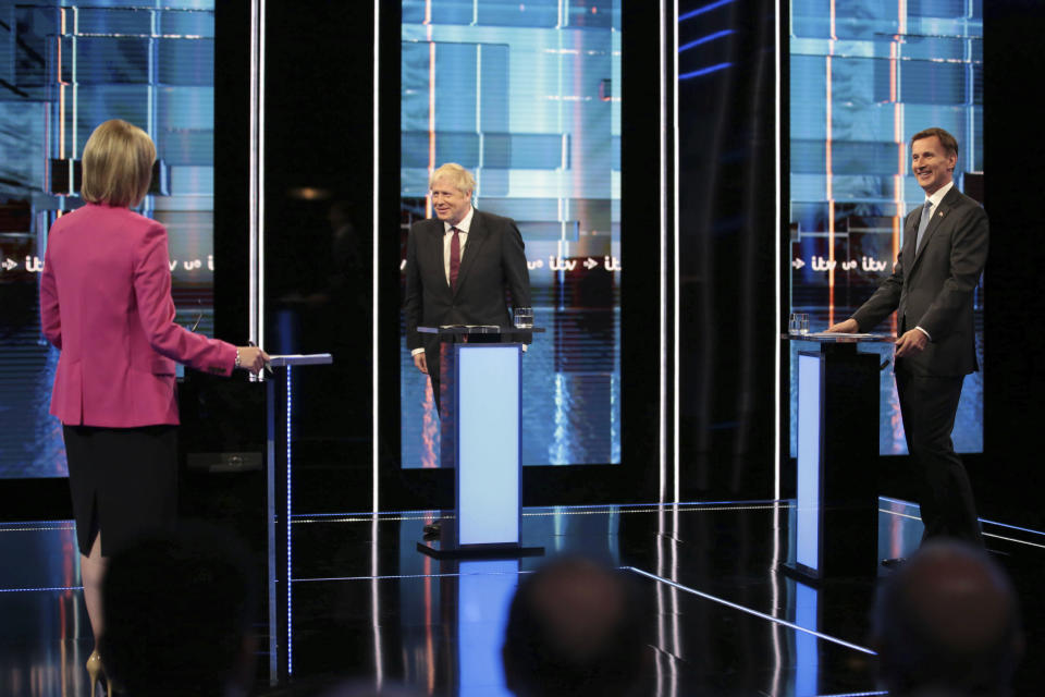 In this photo issued by ITV, showing Britain's Conservative Party leadership candidates Boris Johnson, centre, and Jeremy Hunt, right, with presenting journalist Julie Etchingham, left, moderating the live head-to-head TV debate hosted by ITV at their studios in Salford, England, Tuesday July 9, 2019. The two contenders, Jeremy Hunt and Boris Johnson are competing for votes from party members, with the winner replacing Prime Minister Theresa May as party leader and Prime Minister of Britain's ruling Conservative Party. (Matt Frost/ITV via AP)