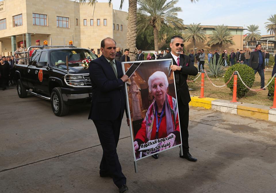 Mourners transport the flag-draped coffin of Iraqi archaeologist, Lamia al-Gailani, seen in the poster, for burial during her funeral procession in the National Museum in Baghdad, Iraq, Monday, Jan. 21, 2019. Iraq is mourning the loss of a beloved archaeologist who helped rebuild her country's leading museum in the aftermath of the U.S. invasion in 2003. (AP Photo/Khalid Mohammed)