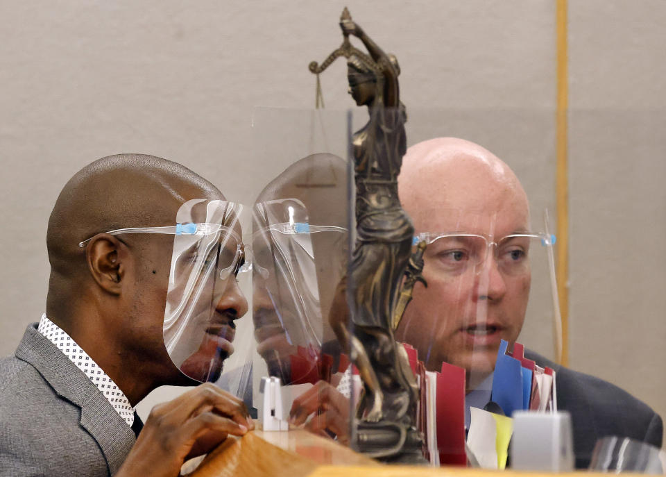 Prosecutor Glen Fitzmartin, right, and defense attorney Kobby Warren visit at the bench with Judge Raquel "Rocky" Jones before recessing for the day during the murder trial of Billy Chemirmir at the Frank Crowley Courts Building in Dallas, Tuesday, Nov. 16, 2021. Chemirmir, 48, faces life in prison without parole if convicted of capital murder for smothering Lu Thi Harris, 81, and stealing her jewelry. He is accused of killing at least 18 women in Dallas and Collin counties. (Tom Fox/The Dallas Morning News via AP, Pool)