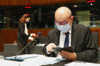 French Foreign Minister Jean-Yves Le Drian looks at his smartphone as he attends a European Foreign Affairs Ministers meeting at the European Council building in Luxembourg, Monday, June 21, 2021. EU foreign ministers were set to approve Monday a new set of sanctions against scores of officials in Belarus and prepare a series of measures aimed at the country's economy. (Johanna Geron/Pool Photo via AP)